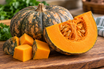 Fresh calabaza squash cut open to show its orange flesh, an ingredient used in traditional pasteles masa