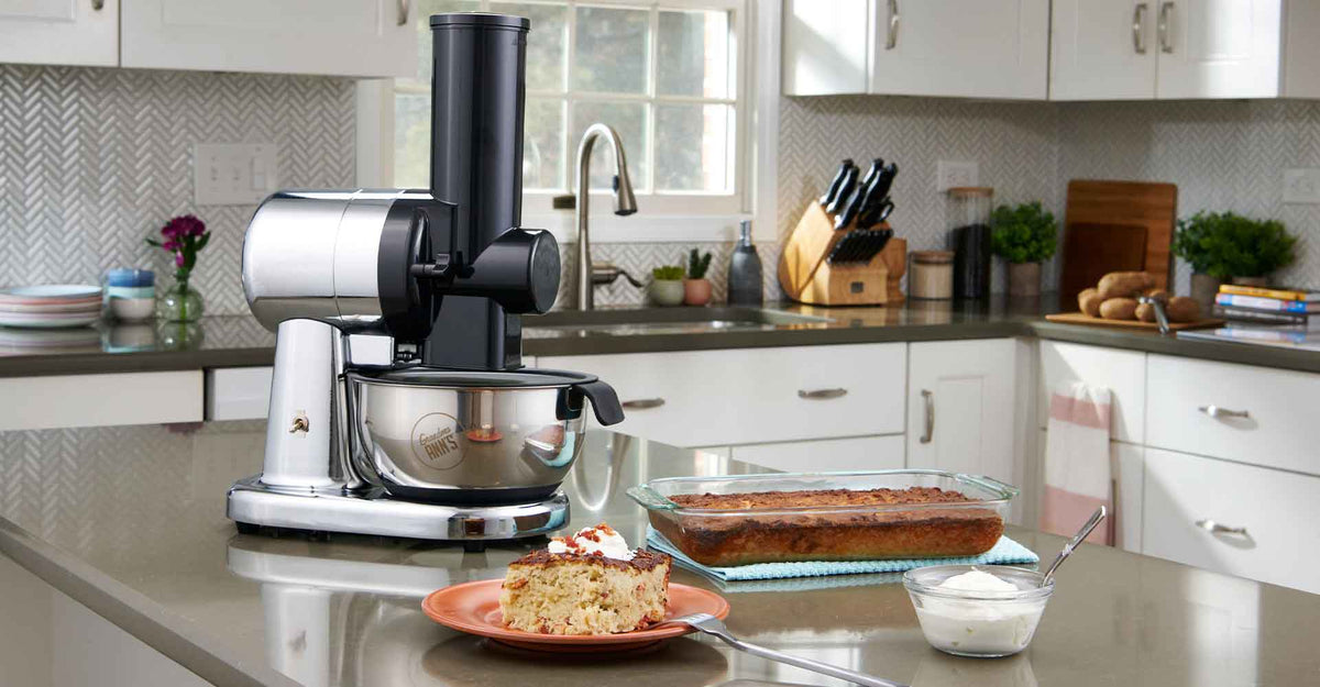 Grandma Ann’s grater in a home kitchen beside a slice of kugelis, sour cream and the baking pan