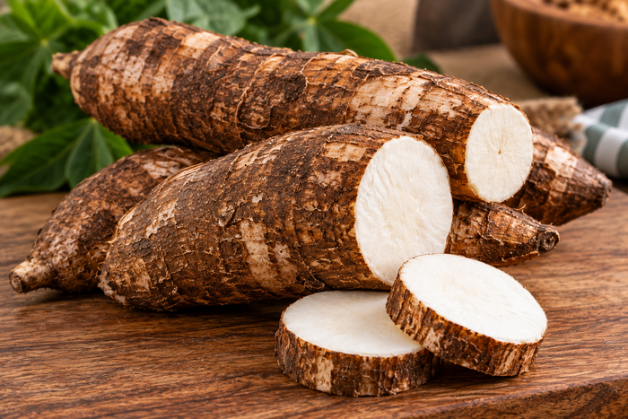 Fresh yuca cassava roots cut open to show the white interior, used in pasteles masa