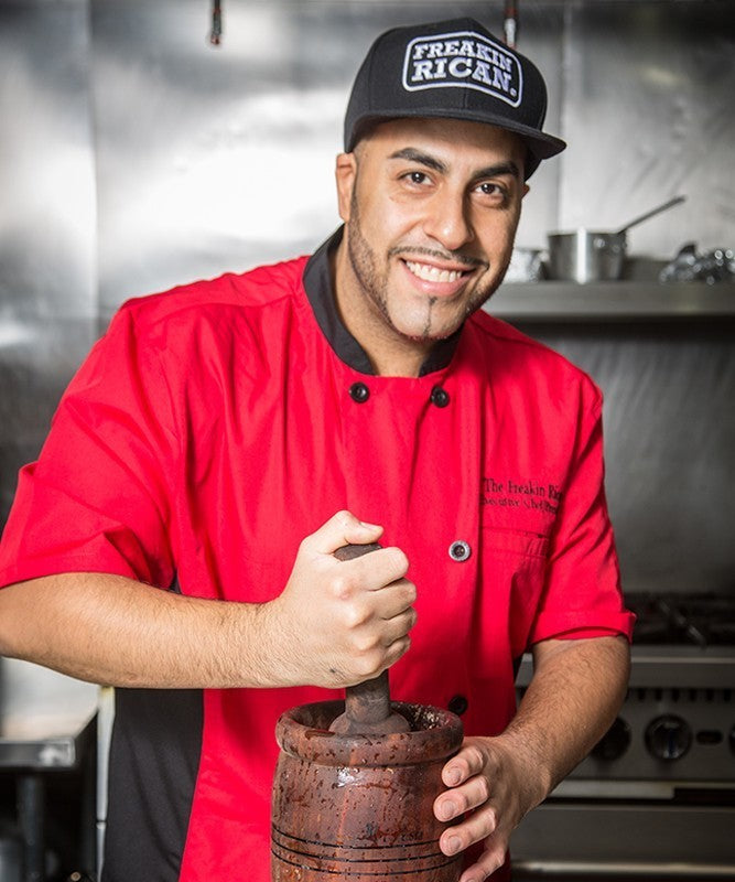 Derick Lopez, The Freakin Rican, usando un pilón de madera en la cocina de su restaurante