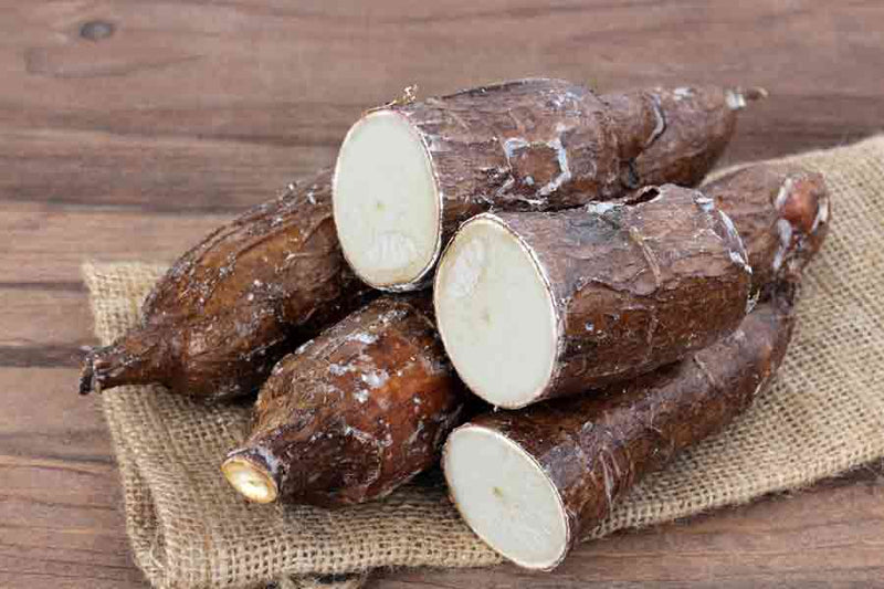 Whole and halved yuca (cassava) roots showing the white interior, used in cassava cake, suman and other traditional recipes